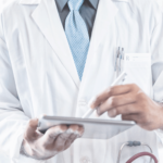 Physician using a tablet to review AR reports done by Virtual OfficeWare specialists