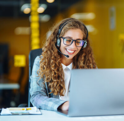 Call center agent with headset working on support hotline in modern office. Video conference.  Оnline training.