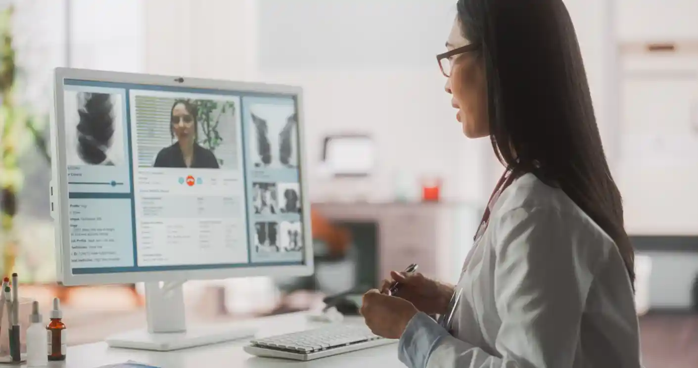 Female doctor consulting a patient via a desktop computer via the Internet 