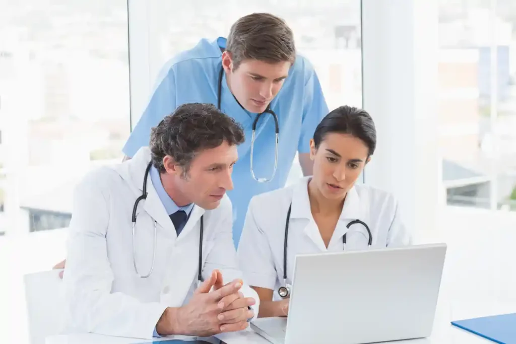 Healthcare Trends to Watch in 2026- Healthcare team using laptop and AI technology to improve care delivery.