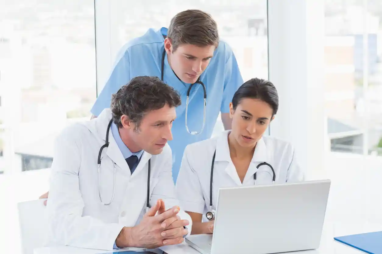 Healthcare Trends to Watch in 2026- Healthcare team using laptop and AI technology to improve care delivery.