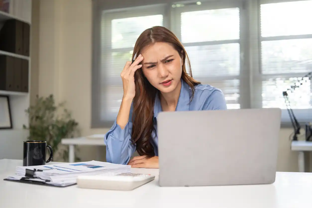 A stressed healthcare administrator reviewing spreadsheets