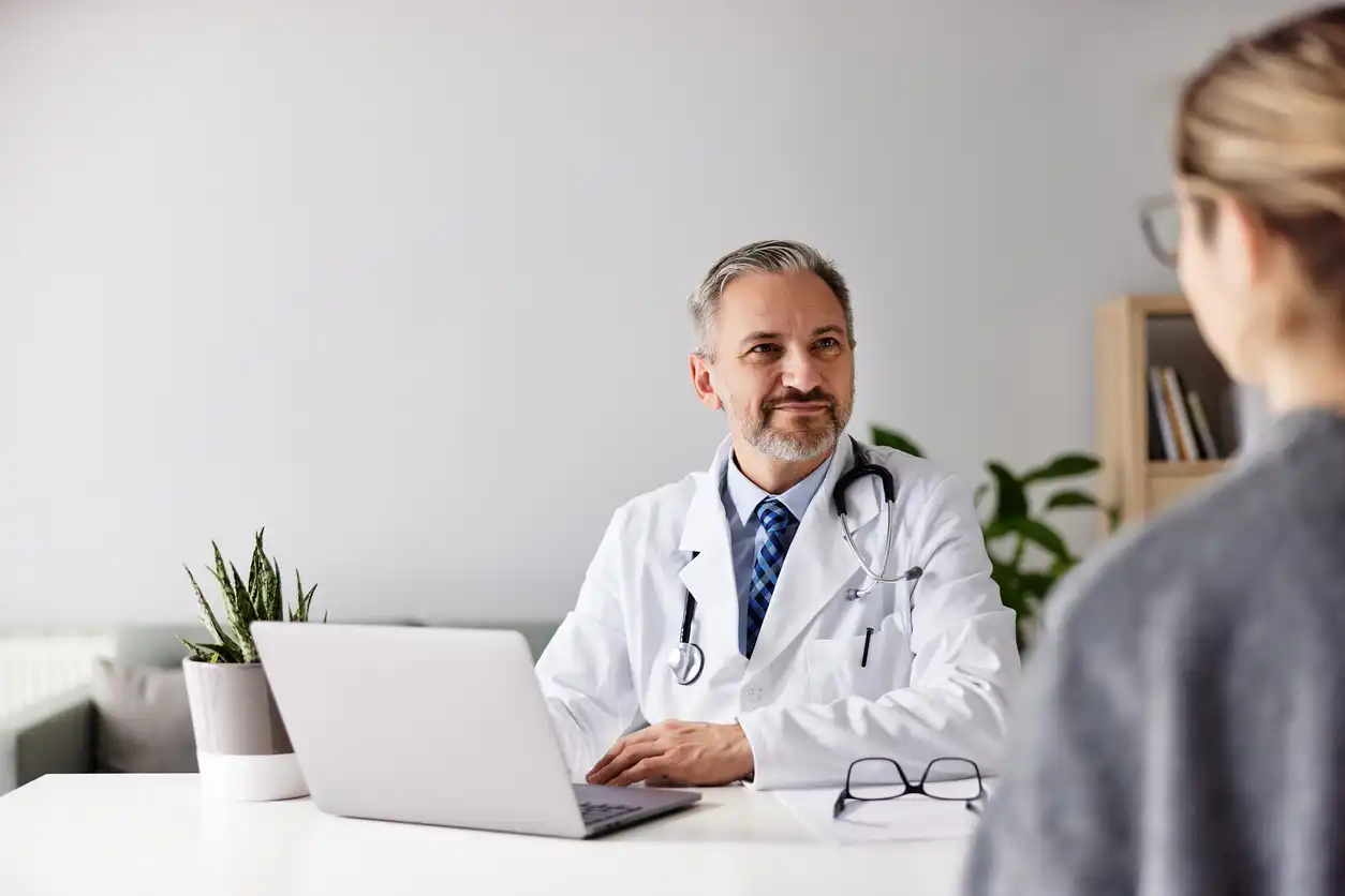 Doctor engaging with a patient while ambient clinical intelligence captures documentation in the background.