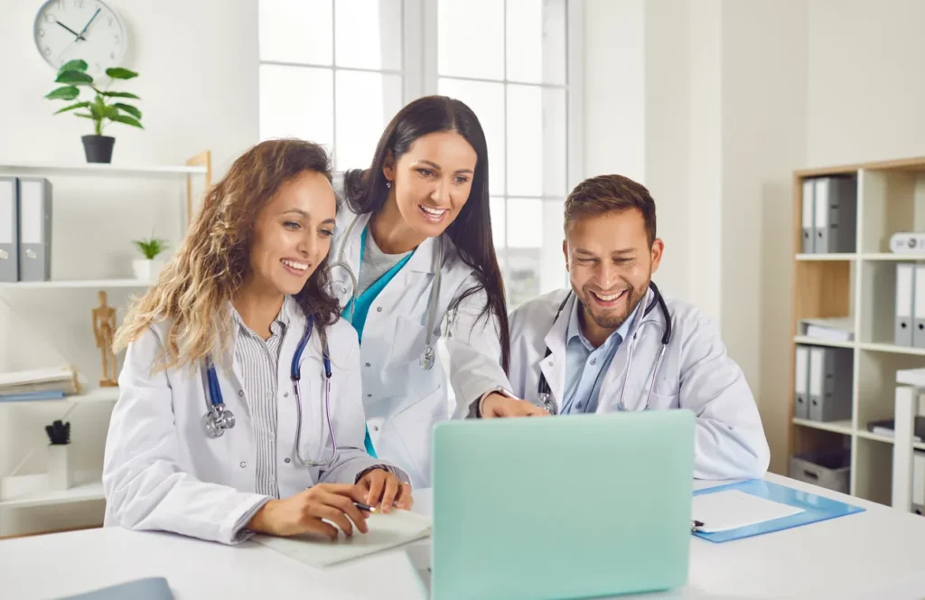 Healthcare staff smiling and collaborating efficiently, illustrating reduced burnout through smarter workflows and technology