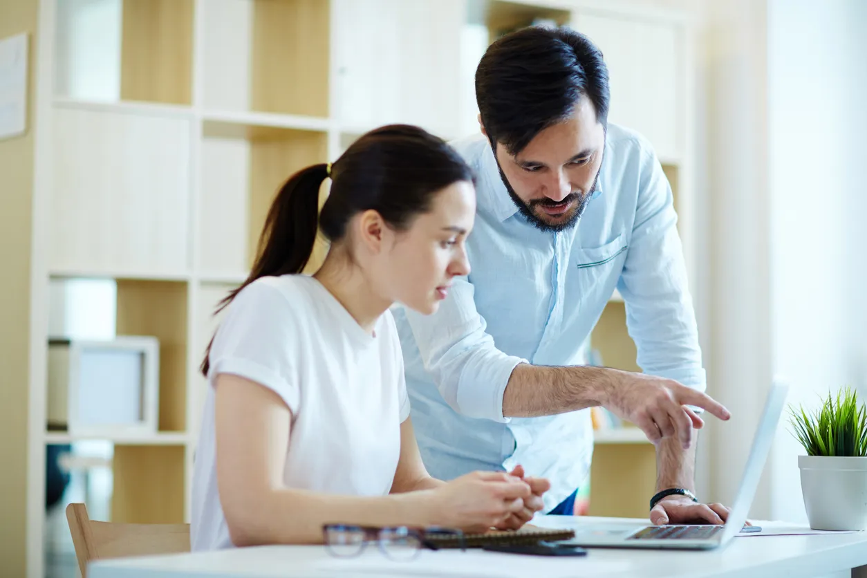 A friendly consultant representing Virtual OfficeWare and showing solutions on a laptop