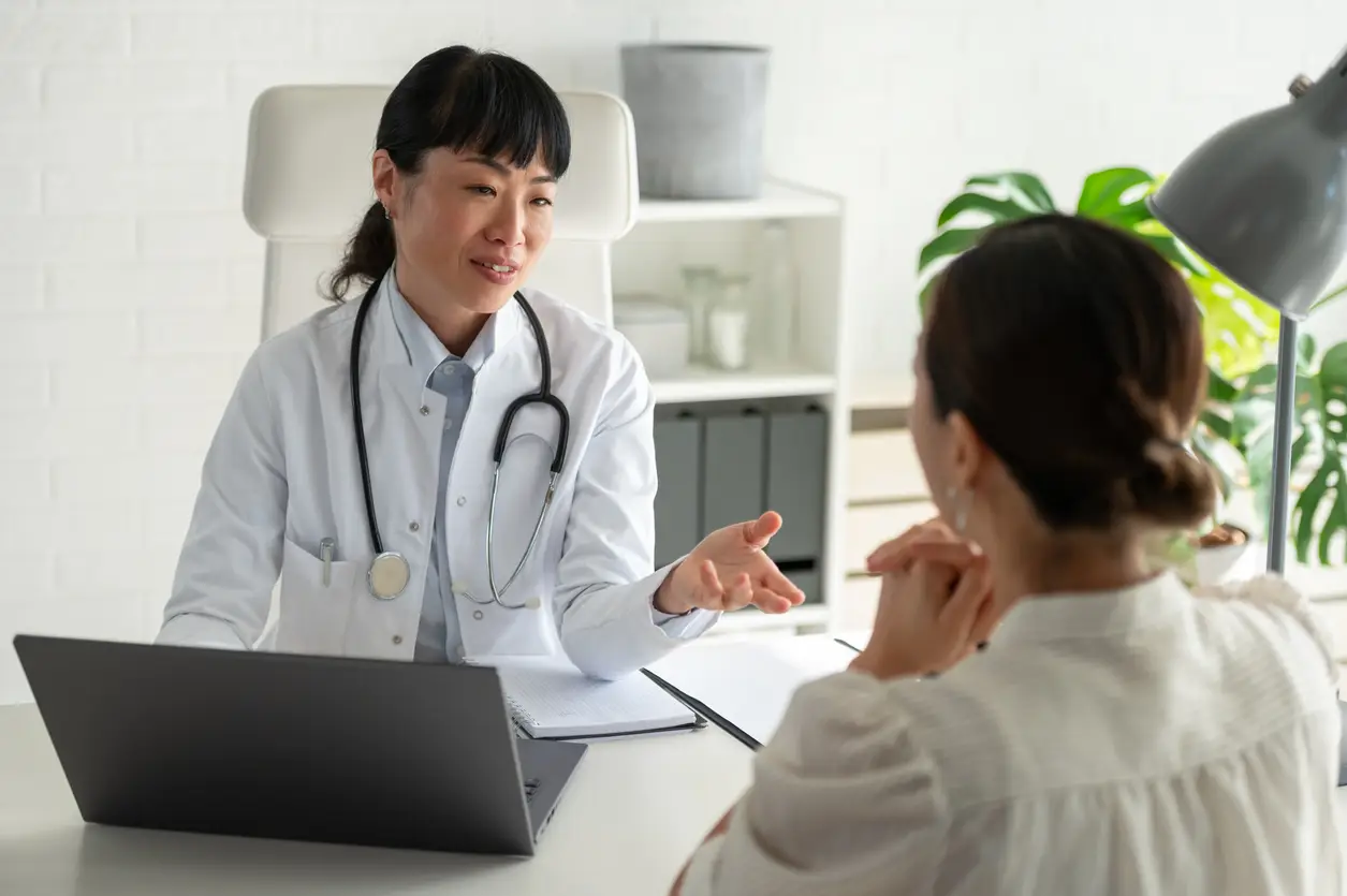 Female doctor completing documentation during a patient clinical visit