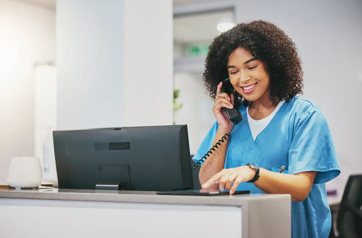 Medical receptionist verifying insurance eligibility before a patient appointment