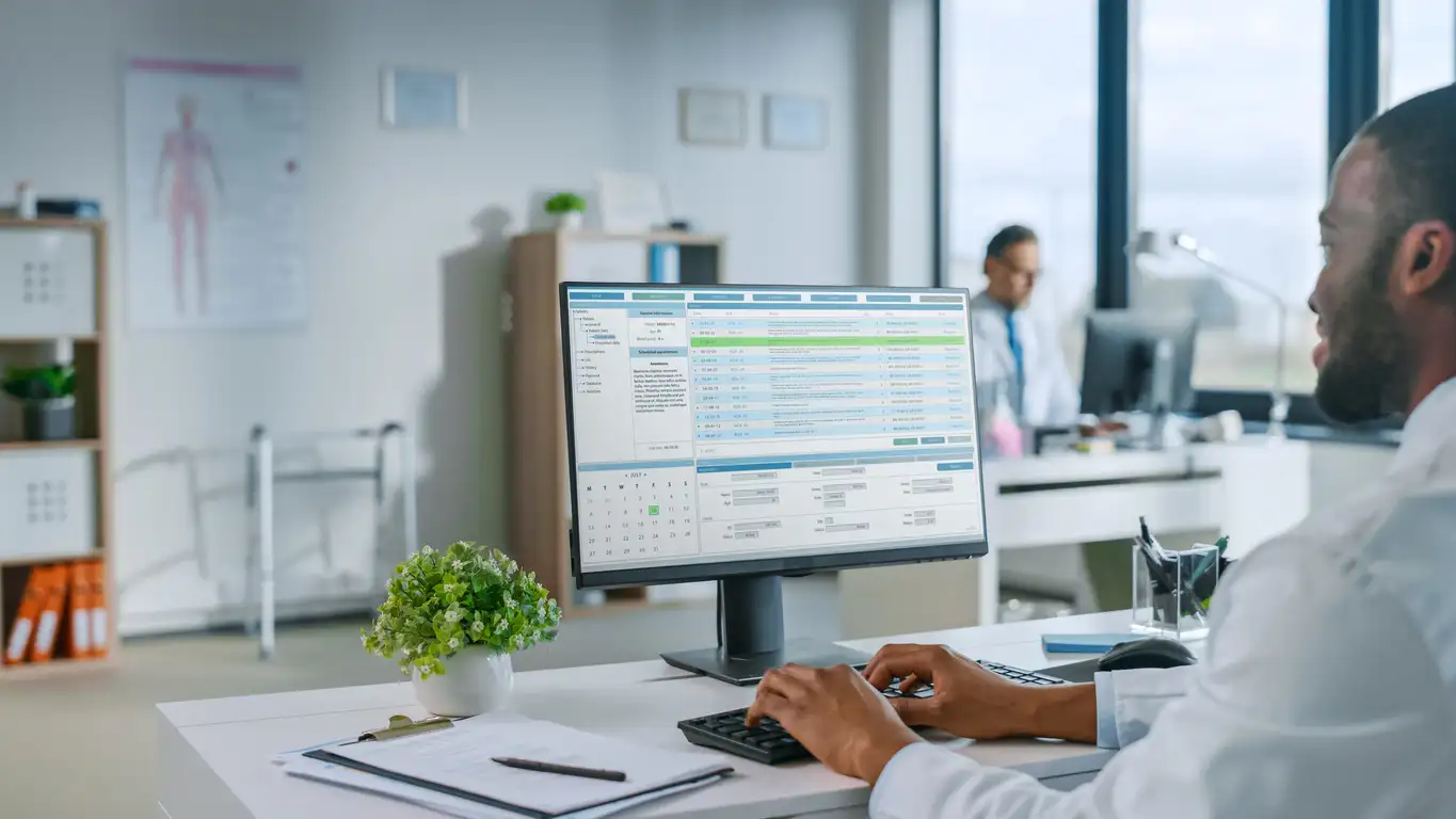 Male physician using EHR technology helping to increase workflow efficiency and reduce bottlenecks by automating routine tasks
