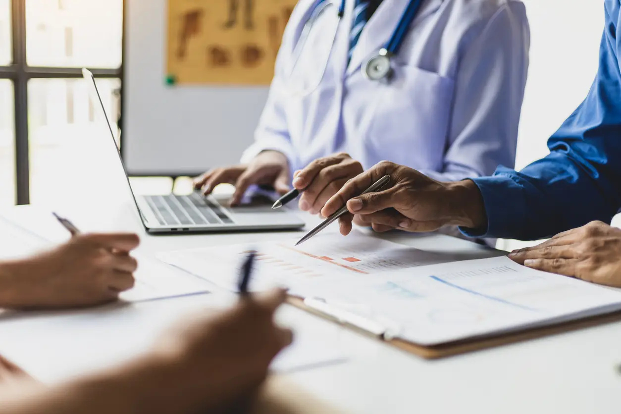 Physician and medical billing team reviewing patient information and revenue cycle workflows in an ambulatory medical practice.